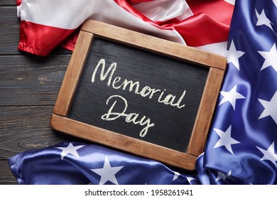 Chalkboard with text MEMORIAL DAY and USA flag on dark wooden background - Shutterstock ID 1958261941
