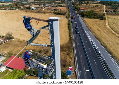 Chalkidiki, Greece - July 12, 2019: Electricians are climbing on electric poles to install and repair power lines after the fierce storm that struck the area
