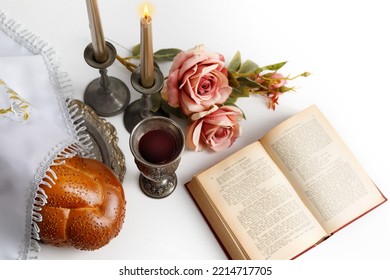 Challah Bread Covered With A Special Napkin, Shabbat Wine, Torah And Candles On White Background. Traditional Jewish Shabbat Ritual. Shabbat Shalom.