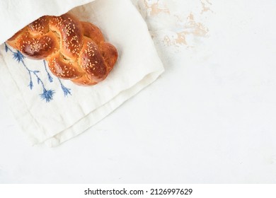 Challah bread. Sabbath kiddush ceremony composition. Freshly baked homemade braided challah bread for Shabbat and Holidays on white background, Shabbat Shalom. Top view. Copy space.