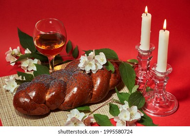 Challah bread, shabbat wine and candles on wooden table. Lighting a candle. Shabbat Shalom
