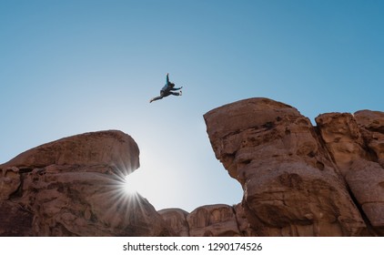 Challenge, risk and freedom concept. Silhouette a man jumping over precipice crossing cliff - Shutterstock ID 1290174526
