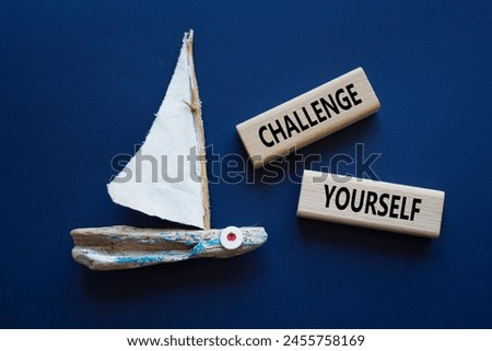 Challenge yourself symbol. Wooden blocks with words Challenge yourself. Beautiful deep blue background with boat. Business and Challenge yourself concept. Copy space.