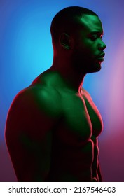 Challenges Only Make You Stronger. Studio Shot Of A Man Posing Shirtless Against A Neon Background.