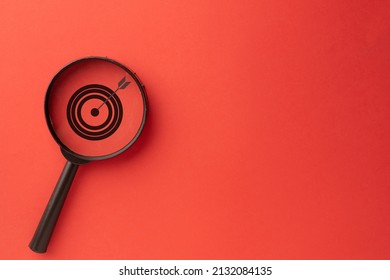 Challenge,Strategy,Focus,Target,objective Business Concept.,Target Icon Inside Magnifier Glass On Left Corner Photo Over Red Wall Background With Coypyspace For Put Your Text Or Logo.