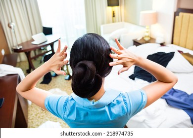 Chambermaid Cleaning In Asian Hotel Room 