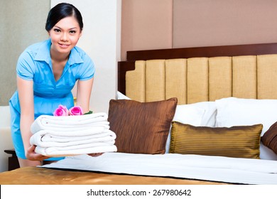 Chambermaid Cleaning In Asian Hotel Room