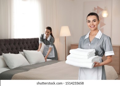 Chambermaid with stack of fresh towels in hotel room. Space for text - Shutterstock ID 1514233658