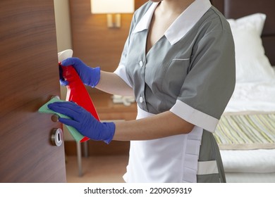 Chambermaid Wearing Mask Cleaning Doorknob In Hotel