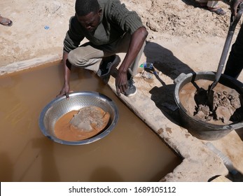 Chami, Mauritania - January 20, 2019: artisanal miner using water to separate gold from crushed ore mixed with mercury. 