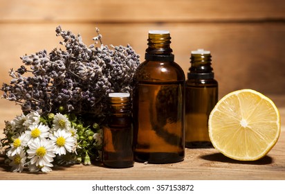 Chamomile, Lemon And Lavender Essential Oil On Wooden Background