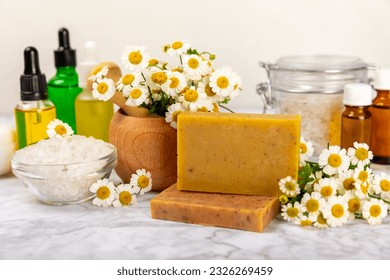 Chamomile Spa. Essential oil, sea salt, chamomile flowers, body cream and handmade soap. Natural herbal cosmetics with chamomile flowers on a textured background.Beauty concept. Cosmetic tube.  - Powered by Shutterstock