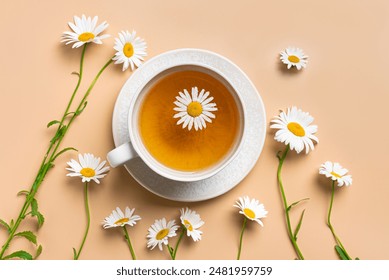 Chamomile tea cup and chamomile buds on neutral beige background, top view. Healthy herbal drinks and daisy flowers, natural eco lifestyle concept. - Powered by Shutterstock