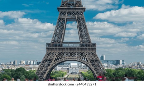 Champ de Mars and the Eiffel Tower timelapse in a sunny summer day. Paris, France. View from square Trocadero with crowd on a viewpoint