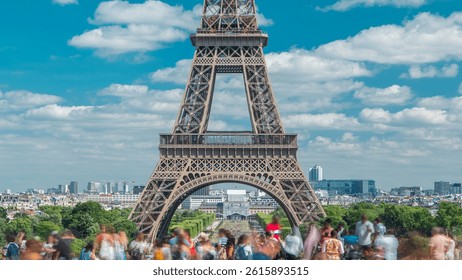 Champ de Mars and the Eiffel Tower timelapse in a sunny summer day. Paris, France. View from square Trocadero with crowd on a viewpoint