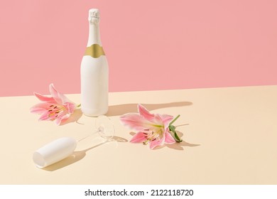 Champagne Bottle And Glass With Pink Flowers On A Beige Background. Minimal Valentine's Day Or Woman's Day Layout. Nature Party Scene