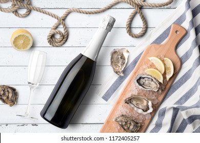 Champagne bottle mockup, on white wooden background, with glass, oysters and blank label to place your design