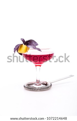 champagne cocktail at wineglass decorated with basil on white background