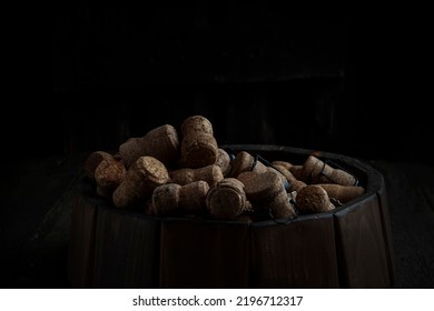 Champagne Corks In Large Quantities Lie On A Wooden Barrel. Rustic Style. The Old Cellar. Copy Space.The Concept Of Food And Drinks.