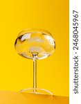 Champagne elegance: Glass with sparkling wine against a vibrant yellow background. With copy space