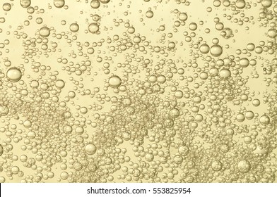 Champagne fizz bubbles soars over a golden background