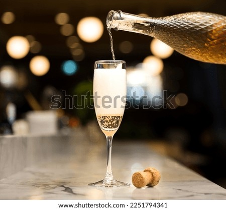 Champagne flute pouring sparkling wine with Christmas lights in the background, holiday season, New Years celebration Stock foto © 