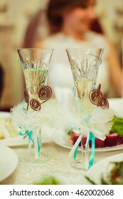 Champagne Flutes Decorated With Wooden Sticks And Mint Ribbons