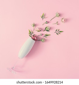 Champagne Glass With Spring Flowers Against Pink Background, Minimal Season Party Concept. Nature Bloom Idea.