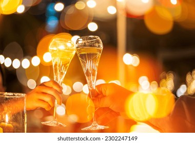 Champagne glasses and human hands,Hands holding champagne glasses on lights background  - Powered by Shutterstock