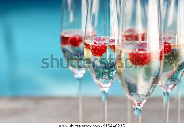 Champagne\
glasses with raspberry. Summer pool\
party