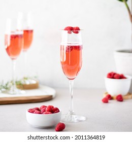 Champagne glasses with red drink. Raspberries. Marble cutting board. Light and bright. - Powered by Shutterstock