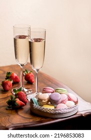 Champagne And Macarons With Strawberries On A Wooden Table