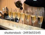 champagne is poured into glasses on the table