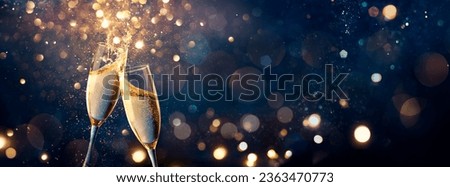 Champagne Toast Celebration - Happy New Year With Golden Glitter On Blue Abstract Background And Defocused Bokeh Lights