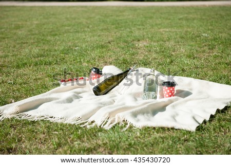 Champagne, water bottle, and strawberries on white blanket