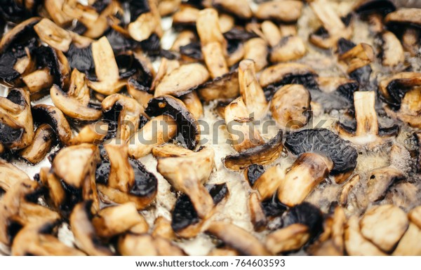 Champignons fry on a large baking sheet. Extreme\
close up.