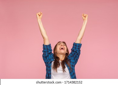 I am champion! Motivated enthusiastic girl in checkered shirt screaming for joy and raising high her fists, celebrating successful winning, incredible victory. studio shot isolated on pink background - Shutterstock ID 1714382152