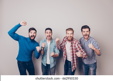 Champions! Four amazed young men are standing and gesturing for the victory on pure background in casual outfit and jeans. They are fans of sports games as football, basketball, hockey, baseball - Powered by Shutterstock