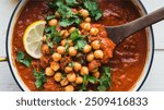 Chana Masala: Hearty chickpeas in a thick, spicy tomato sauce. Robust flavors from a blend of spices, balanced with tangy notes and a fresh burst of cilantro