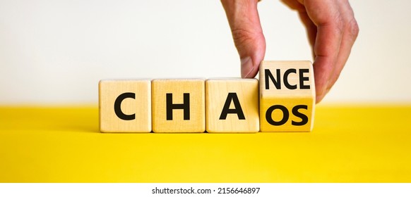 Chance or chaos symbol. Businessman turns a cube and changes the word 'chaos' to 'chance'. Beautiful yellow table, white background, copy space. Business, chaos or chance concept.
