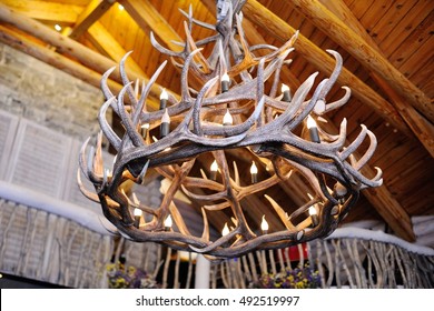 chandelier made of deer antlers on a wooden background - Powered by Shutterstock