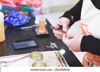 A Chandler Or Candle Maker Adds A Wick To Scented Hand Made Candles