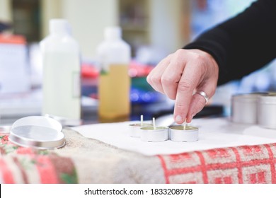 A Chandler Or Candle Maker Adds A Wick To Scented Hand Made Candles