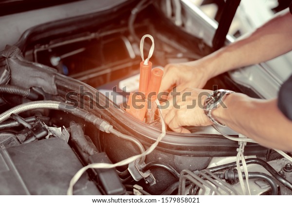 change car
battery, mechanic is checking the
engine
