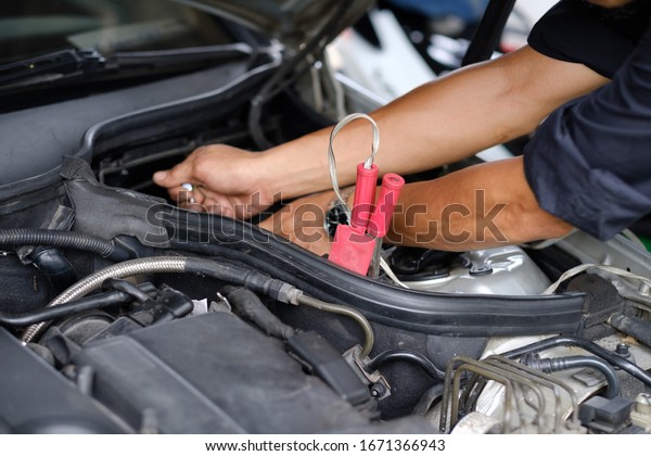 change car
battery, mechanic is checking the
engine
