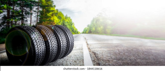 Change a car seasonal tyre summer forest road with trees background. Change for winter tire. Banner Selling off. Or Background automechanic 