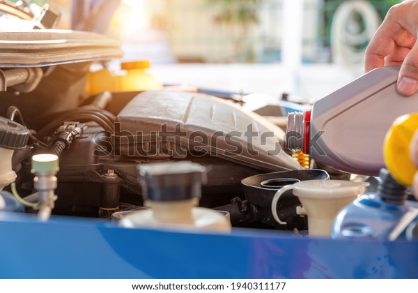 Change the Oil of machine. Car mechanic\
replacing and pouring fresh oil. Maintenance car repair automotive\
.refil fresh oil.Engine oil refueling\
point.