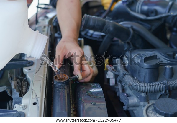 Change the oil, Mechanic pouring clean water in\
to engine.