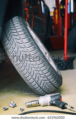 Change of tires for the car on the floor of the auto service. The equipment for car-care center. Screwdriver                               