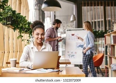 Let’s Change The World We Work In, Not Just The Way We Work. Attractive Business Woman Working At Desk In Modern Office.